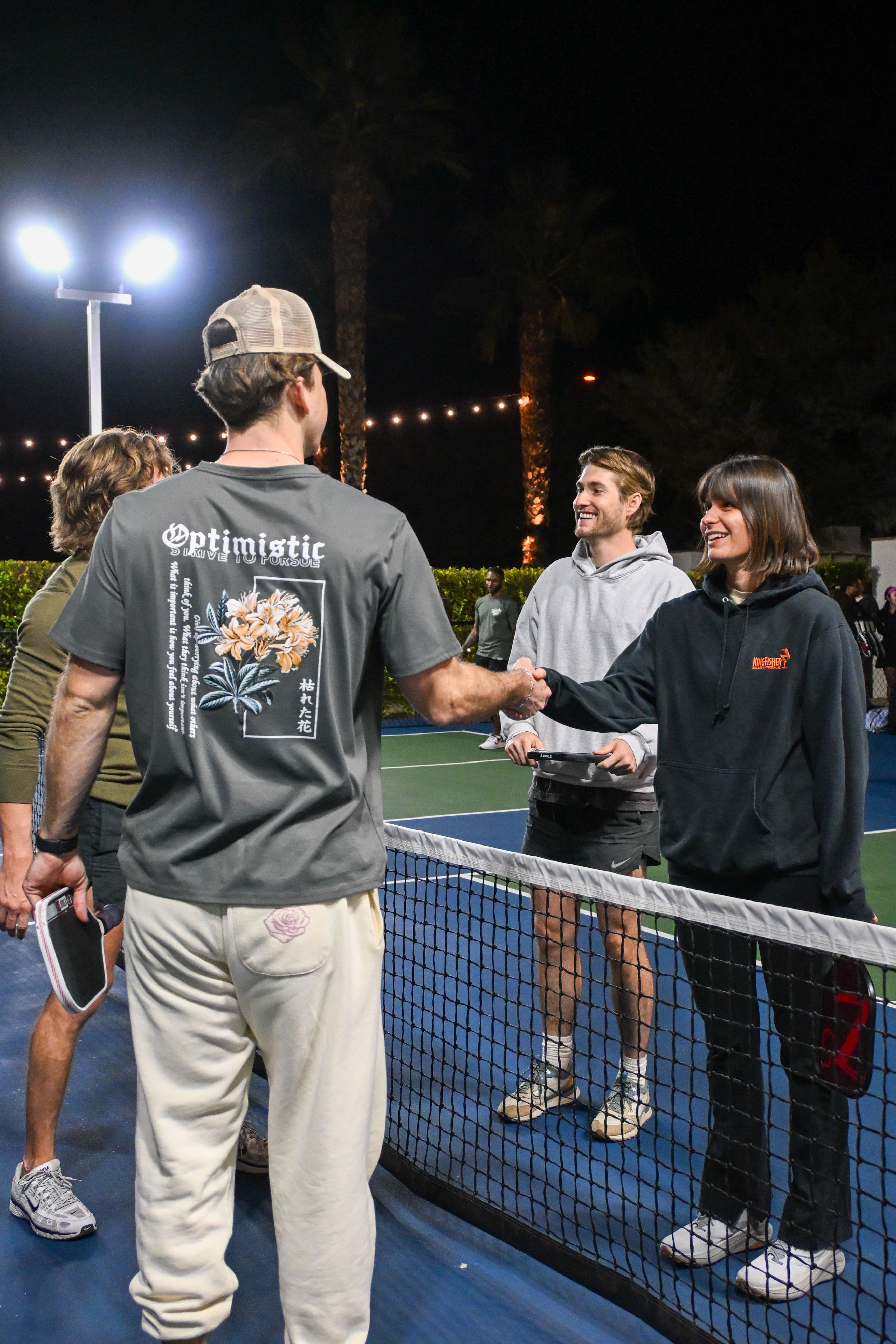 Friends laughing on a pickleball court
