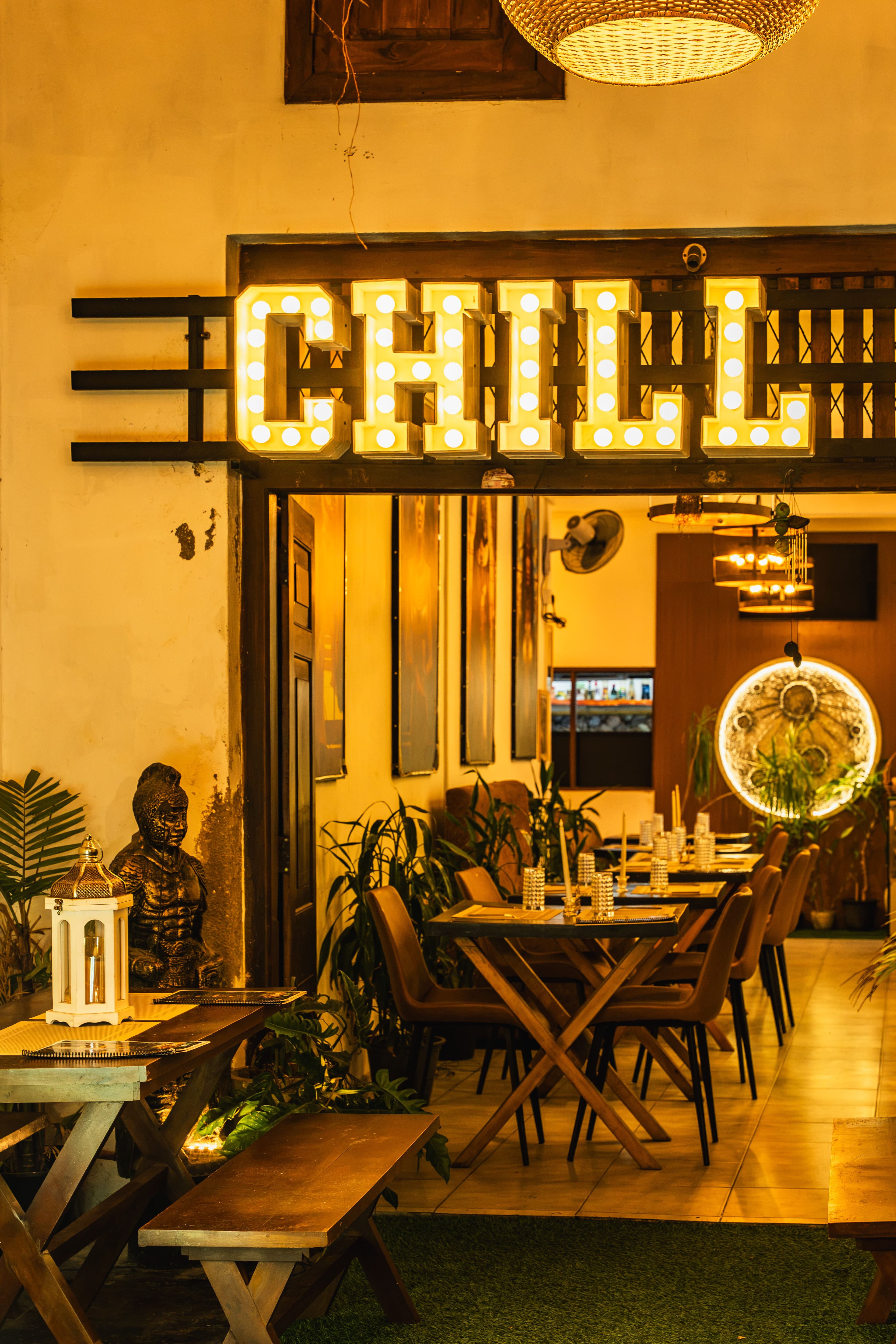 Glowing marquee sign above a candlelit restaurant entrance