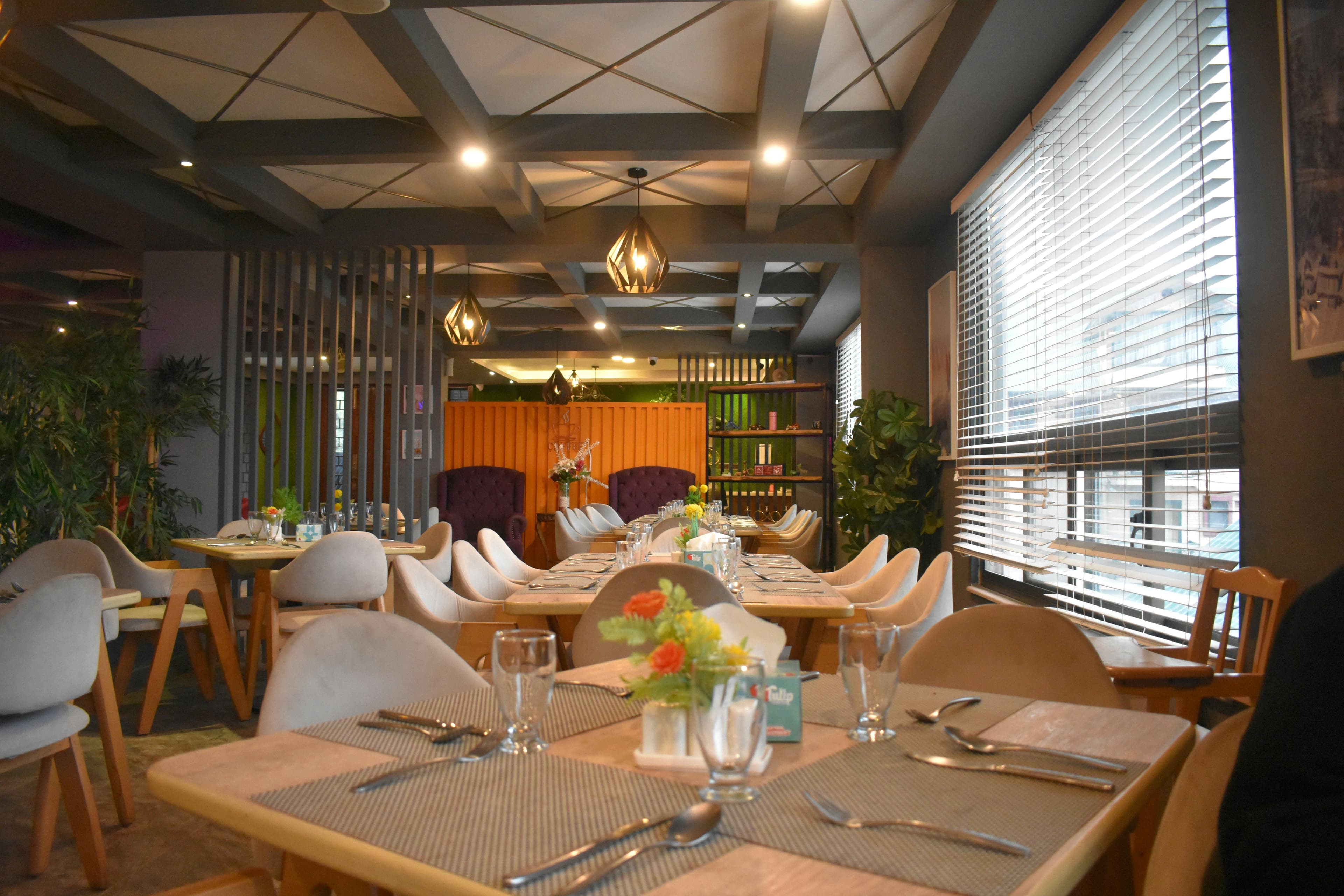 Bright modern dining room with set tables and fresh flowers